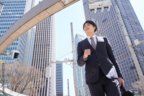 オフィス街で颯爽と歩く日本人男性ビジネスマン photo