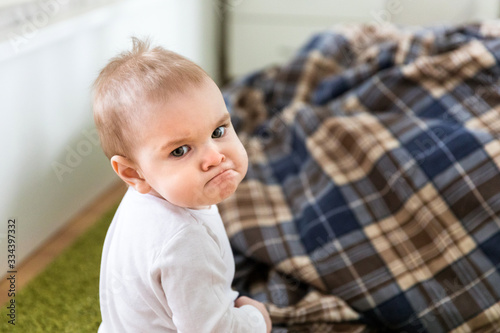 Offended angry upset kid sitting on the floor