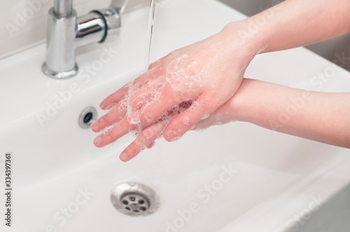 Caucasian woman washing hands rubbing with soap and rinsing with water. Concept of coronavirus prevention, hygiene to stop spreading corona virus.