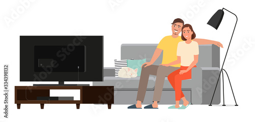 Young couple man and woman watching tv while sitting on the couch.