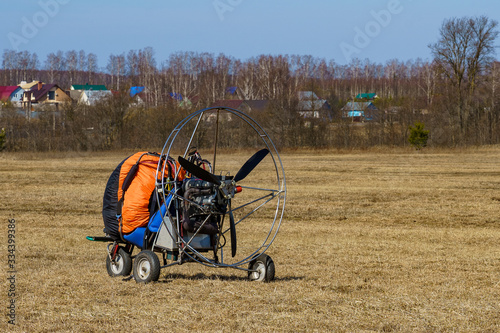 paraglider stands on the field prepared for flight photo