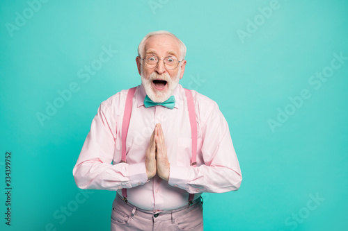 Profile photo of funny excited hipster grandpa raise arms begging to go senior party tonight wear specs pink shirt suspenders bow tie pants isolated teal color background