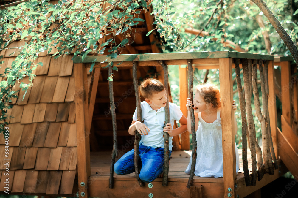 Φωτογραφία Little boy and girl playing in treehouse at forest park, Active kids on playground, Child enjoying activity in a climbing adventure park on summer sunny day