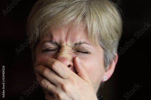 Sneezing woman with hand over nose, seasonal flue or allergy, corona virus symptoms