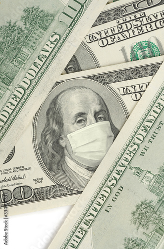 Portrait of Franklin on 100 dollar banknote with medical mask. The concept of coronavrius epidemic and the financial crisis caused by this collapse photo