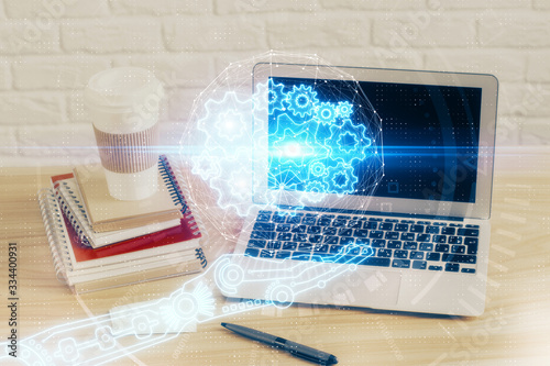 Double exposure of desktop computer and technology theme hologram. Concept of software development.