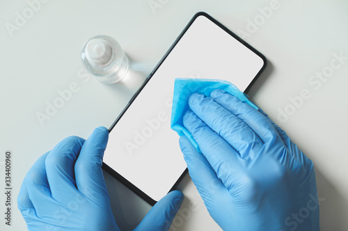 Foto Cleaning cellphone with sanitizer and cloth
