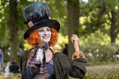 Portrait of a beautiful young woman with red hair, colorful cylinder and colorful make-up