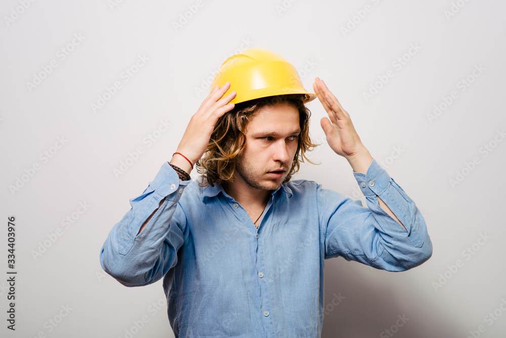 man close-up in helmet , holding his head by hand