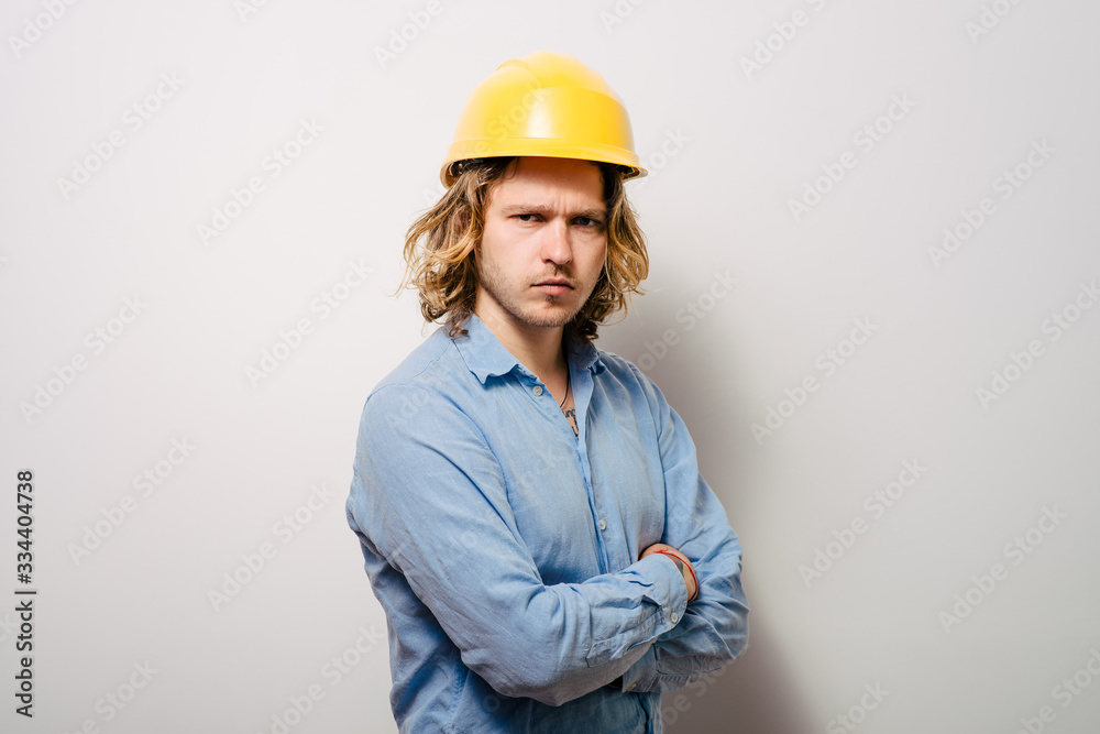 Handsome young man with protective helmet on his head and arms crossed