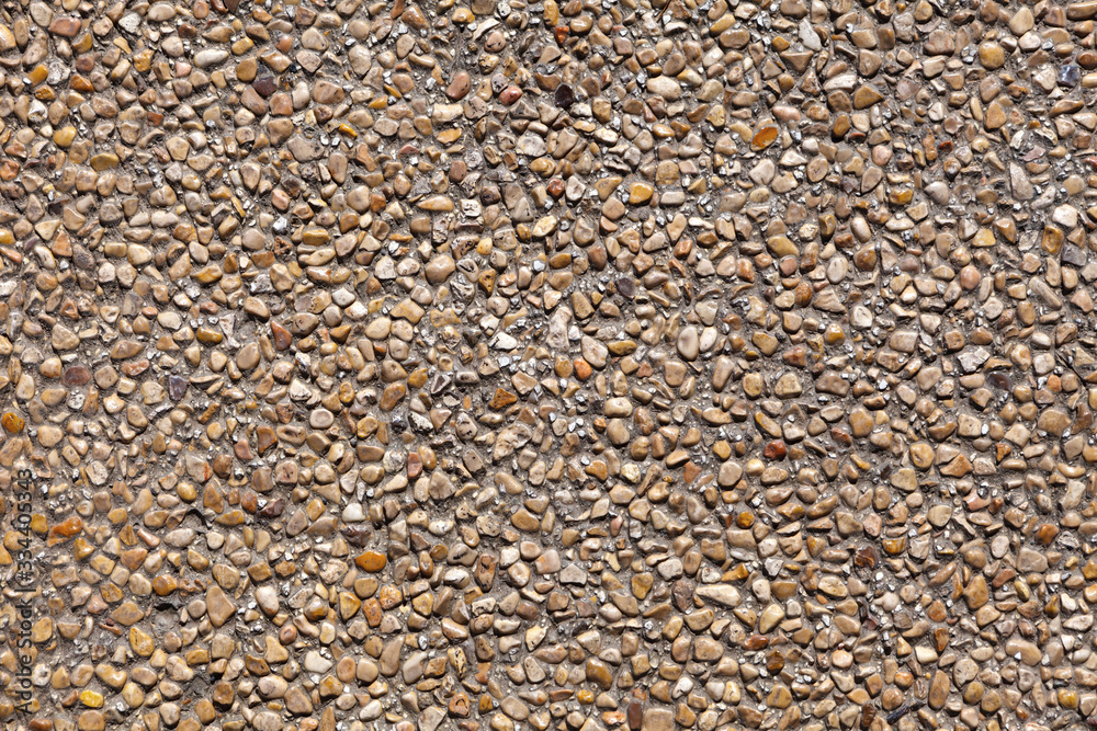 The wall is decorated with small natural pebbles of brown color The wall is decorated with small natural pebbles of brown color