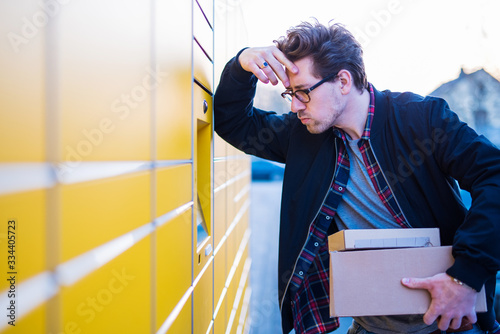 Ein Mann an einer Packstation, Pakete abholen und verschicken photo