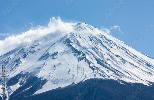 A closeup of the peak of the highest mountain in Japan  Mt. Fuji or Fujisan  in clouds at the beginning of spring