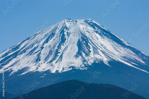 Mt Fuji or Fujisan or Fujiyama covered in snow in Japan from a distance in early spring