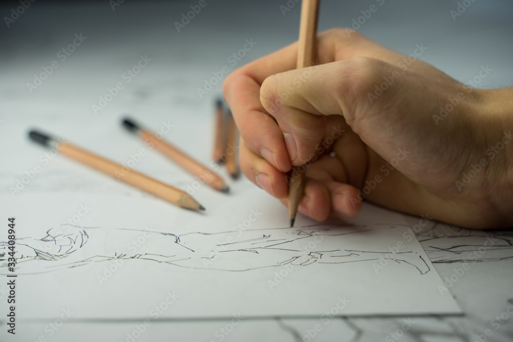 A top view flat lay of many figure drawing pencil and marker sketches. The artist worskspace with male and female drawings and pencils on the white paper, art, craft, creativity, inspiration, concepts A top view flat lay of many figure drawing pencil and marker sketches. The artist worskspace with male and female drawings and pencils on the white paper, art, craft, creativity, inspiration, concepts