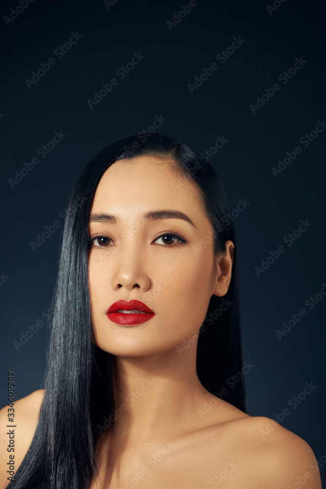 Beautiful asian woman with long hair posing in studio on black background.