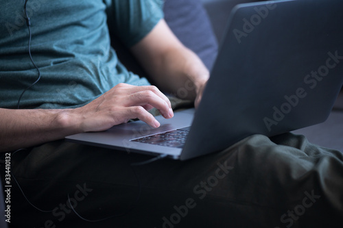 Close up business man working on sofa via laptop at his office.Young male manager using portable computer device in coffee shop.Male hands typing on the notebook keyboard.Work at home.