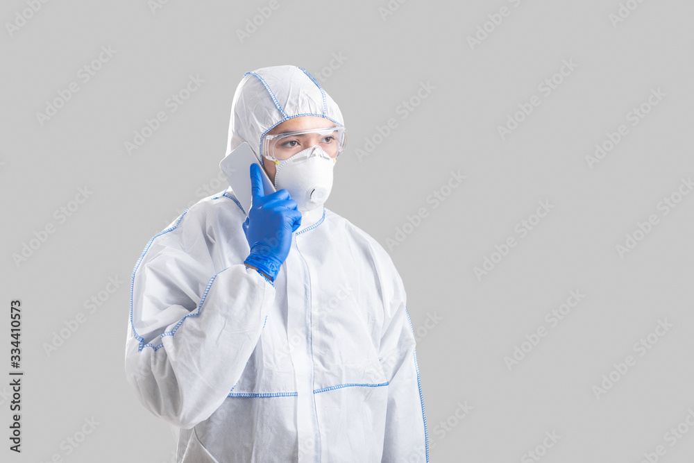 Man in protective suit with gloves speaks on phone