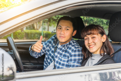 Young asian couple happiness sitting in car show thumb up. Travel concept, Safety first insurance concept, New car concept