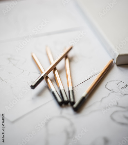 A top view flat lay of many figure drawing pencil and marker sketches. The artist worskspace with male and female drawings and pencils on the white paper  art  craft  creativity  inspiration  concepts