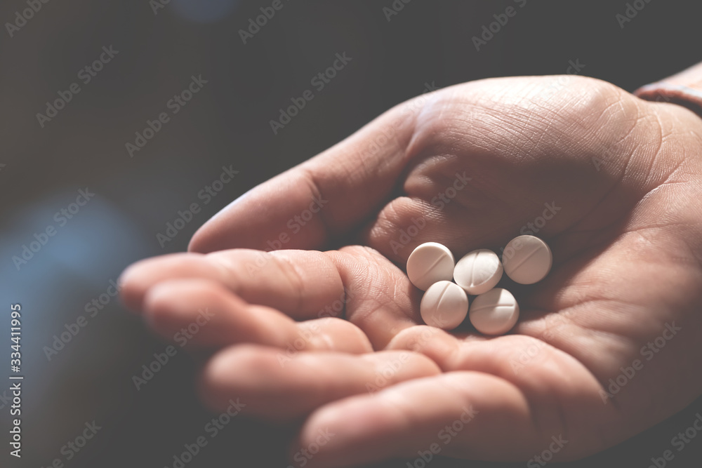 close up hand man holding taking multiple pills. Stop drug use Taking Medication health care medical concept. narcotic sleeping pills dark background. close up hand man holding taking multiple pills. Stop drug use Taking Medication health care medical concept. narcotic sleeping pills dark background.