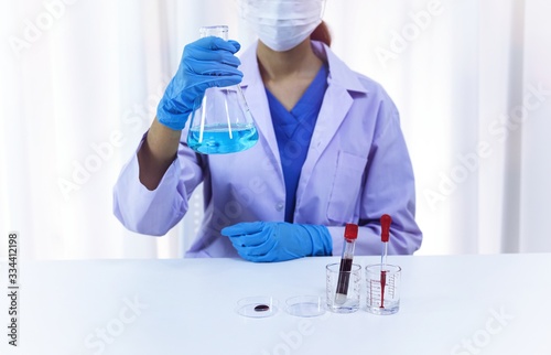 Scientist holding Coronavirus covid-19 infected blood sample tube DNA testing of the blood in the laboratory with blood sample collection tubes and syringe Coronavirus Covid-19 vaccine research.