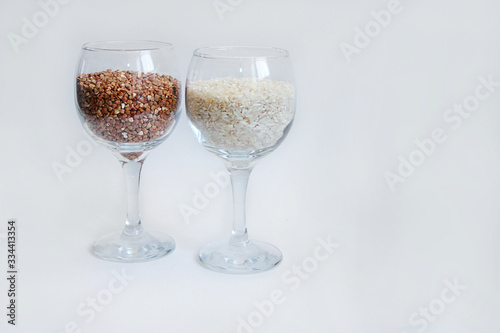 rice and buckwheat groats stand in a wine glass on a white background