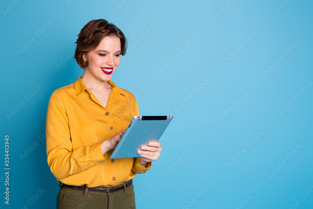 Photo of pretty business lady hold tablet hands freelancer worker reading corporate report company website wear yellow shirt green pants isolated bright blue color background Photo of pretty business lady hold tablet hands freelancer worker reading corporate report company website wear yellow shirt green pants isolated bright blue color background