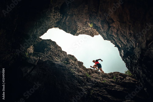 Runner silhouette, man running in rocky mountains. Unusual trail run sport photo