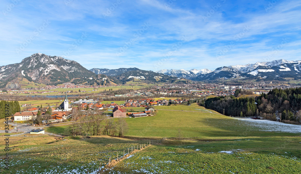 View of Sonthofen with snow-covered mountains and green pastures. Allgäu Alps, Bavaria, Germany