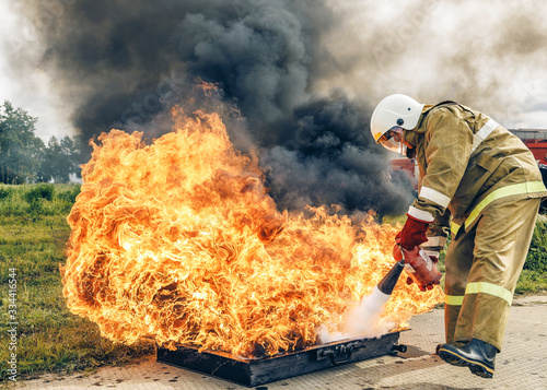 A firefighter extinguishes the fire with a fire extinguisher