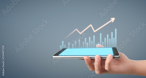  Graph growth and increase of chart positive indicators in his business,tablet in hand