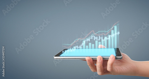  Graph growth and increase of chart positive indicators in his business,tablet in hand