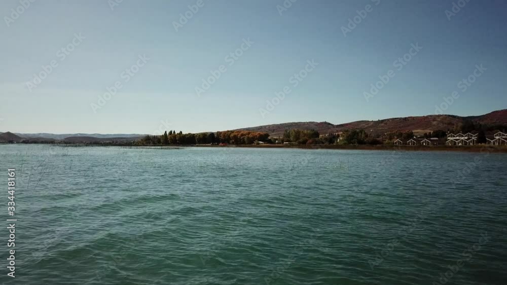 Drone shot seen flying across Bear Lake, Utah. A mountain is seen in the background. Drone shot seen flying across Bear Lake, Utah. A mountain is seen in the background.