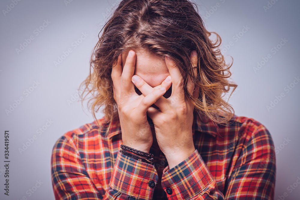 Man covering his face
