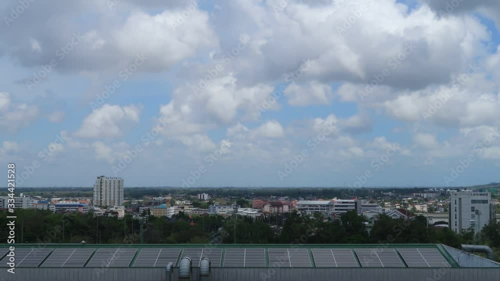 Futuristic city or cityscape & Innovative technology concept background TimeLapse of solar panels on building roof with business green environment town & beautiful white cumulus cloud, sunny blue sky Futuristic city or cityscape & Innovative technology concept background TimeLapse of solar panels on building roof with business green environment town & beautiful white cumulus cloud, sunny blue sky