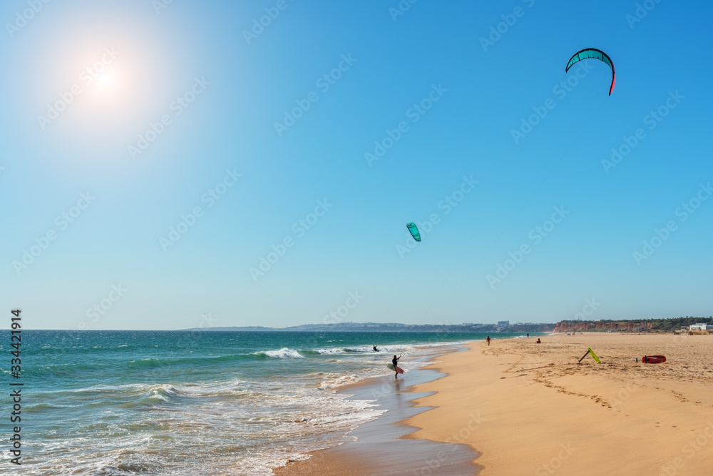 The athlete practices kate board surfing the sea on the waves. Summer in Portugal Algarve.