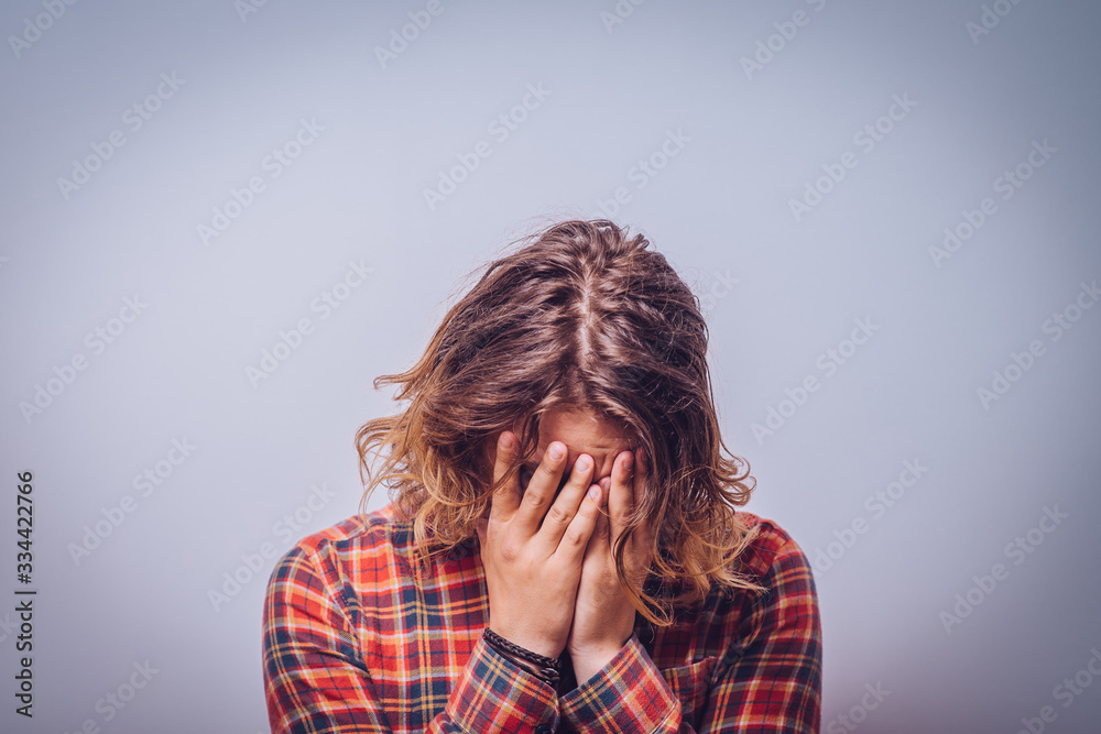 Man covering his face