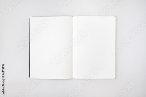 Mockup de libreta abierta con hojas blancas sobre sondo gris claro photo