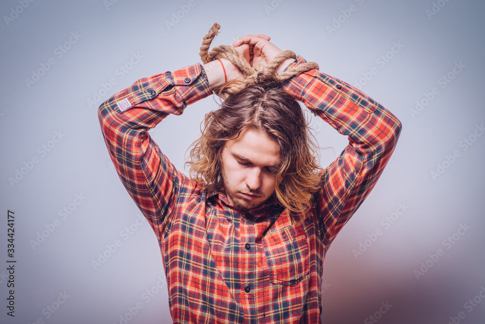 Tortured business man holding his hands tied with a rope Tortured business man holding his hands tied with a rope