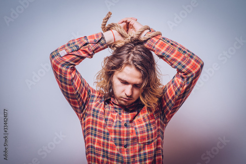 Tortured business man holding his hands tied with a rope