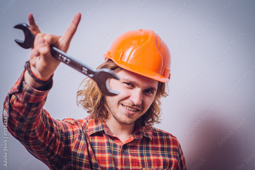 Portrait of young handyman holding a wrench Portrait of young handyman holding a wrench