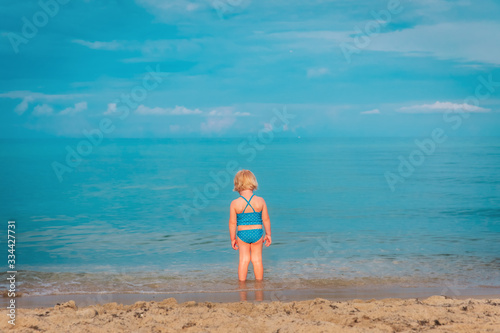 little girl go swim on beach vacation