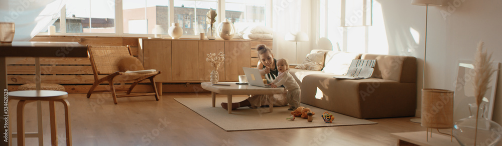 Caucasian mother working from home, having a work video call, daughter playing nearby. Stay home, quarantine remote work Caucasian mother working from home, having a work video call, daughter playing nearby. Stay home, quarantine remote work