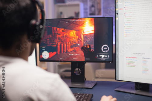 Obraz na plátně Guy with headphones playing shooter game