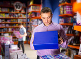 Father choosing playthings for child in toy store