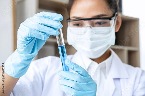 Scientist or medical in lab coat holding test tube with reagent, Laboratory glassware containing chemical liquid, Biochemistry laboratory research