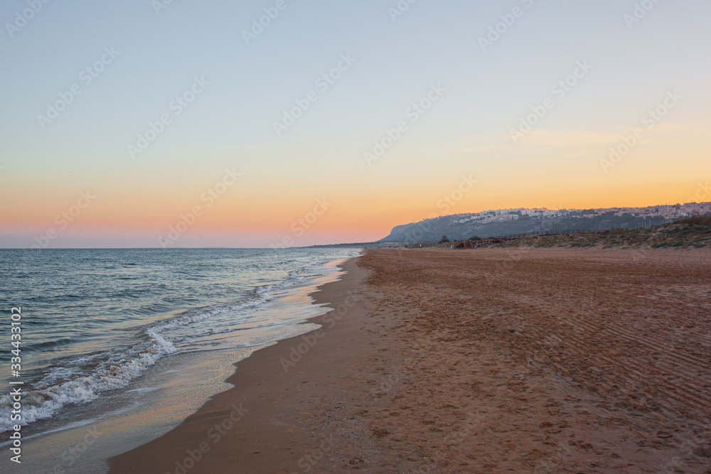 lonely mediterranean beach at sunset