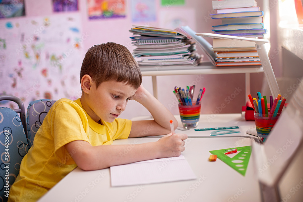 Child doing homework with books and textbooks at home. Learning at home, self quarantine concept. Family at home. Epidemic of coronavirus. Self-isolation, home quarantine. Distance learning at home. Child doing homework with books and textbooks at home. Learning at home, self quarantine concept. Family at home. Epidemic of coronavirus. Self-isolation, home quarantine. Distance learning at home.