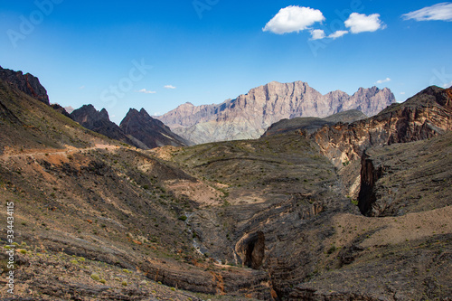 Mountain and valley view along Wadi Sahtan road and snake canyon in Al Hajir mountains between Nizwa and Mascat in Oman photo